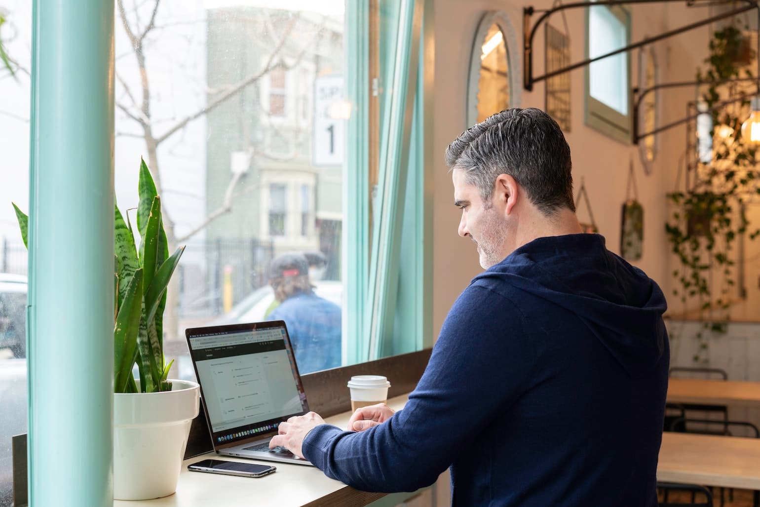 Man In Cafe Working On Computer